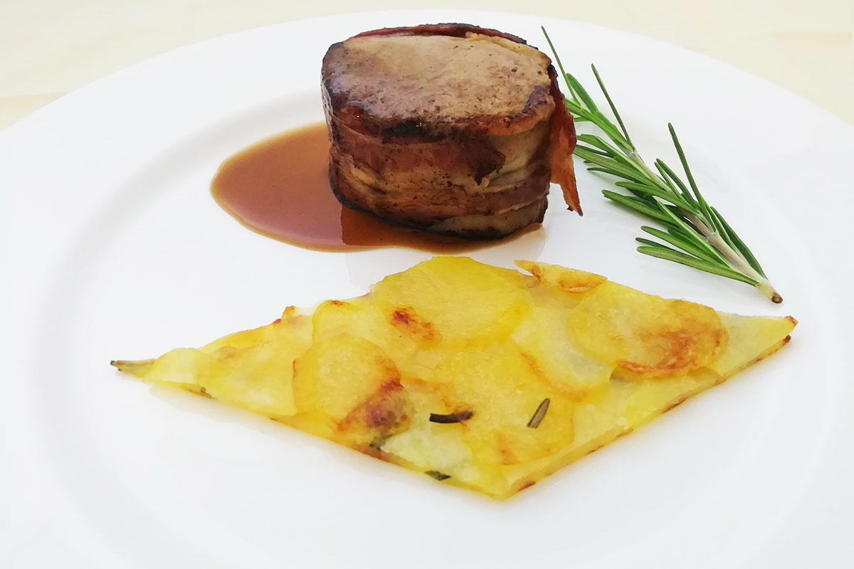 Filetto di maiale con alloro e bacon su pavé di Patate di Bologna D.O.P.